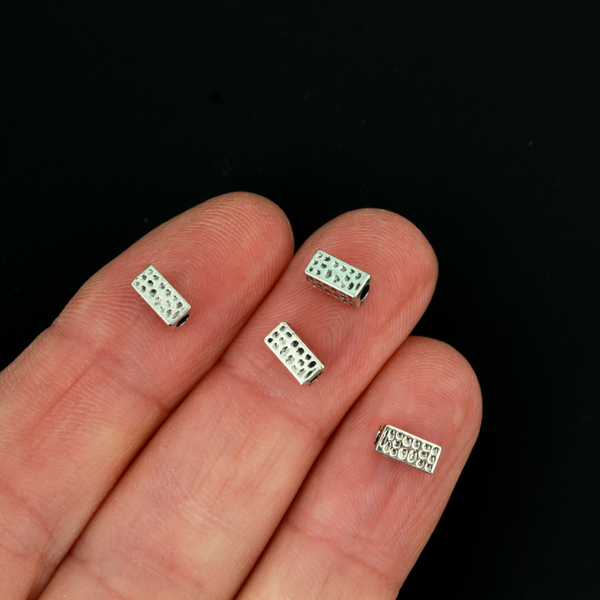 Rectangle shaped spacer beads that have a dimple dot pattern on all four sides 6mm x 3mm