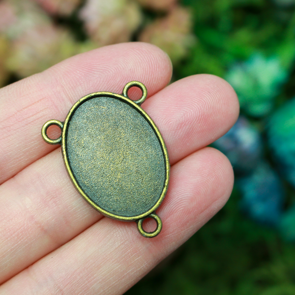 Flat oval rosary centerpiece cabochon setting in an antiqued bronze tone color. This is a plain edge bezel cup with a 25mm x 18mm tray.